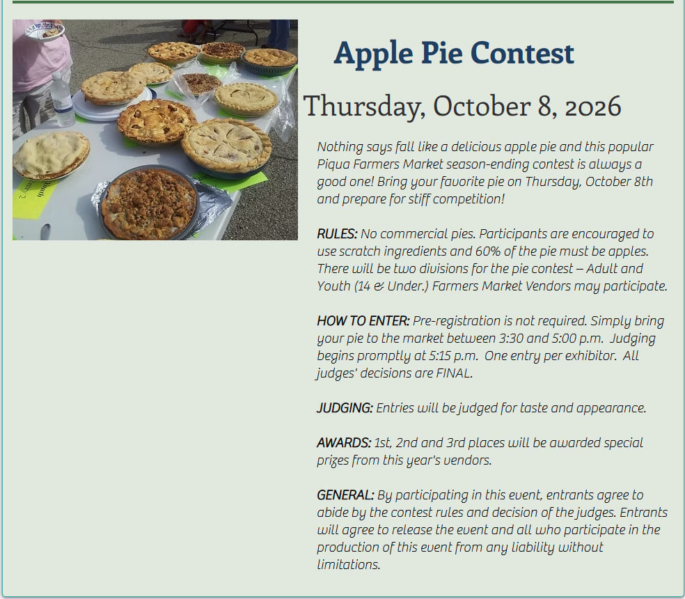 Several homemade pies are displayed on a table with labels, set up outdoors for judging at an apple pie contest event.