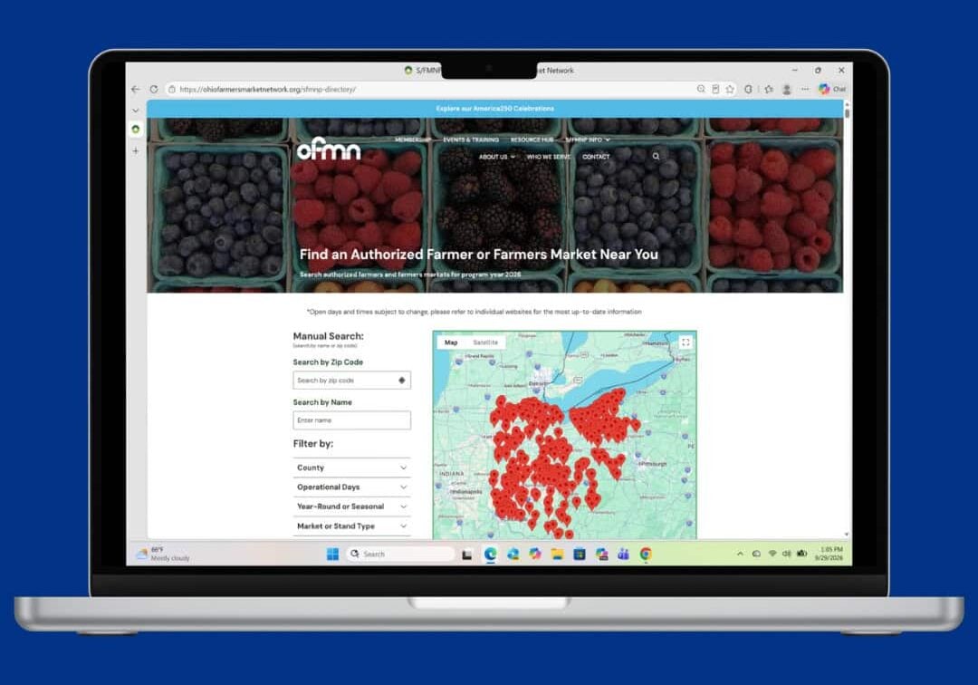 A laptop displays a website showing a search tool for finding authorized farmers markets, with a map marked by red location pins and berry images at the top.